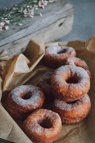 A pile of donuts in powdered sugar. Bite donut.