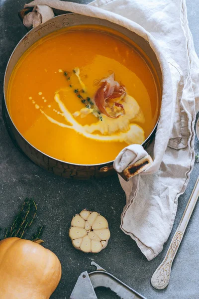 Casserole of pumpkin soup, with prosciutto and thyme on a gray background, top view — Stock Image Casserole Pumpkin Soup Prosciutto Thyme Gray Background Top View Royalty Free Stock Images