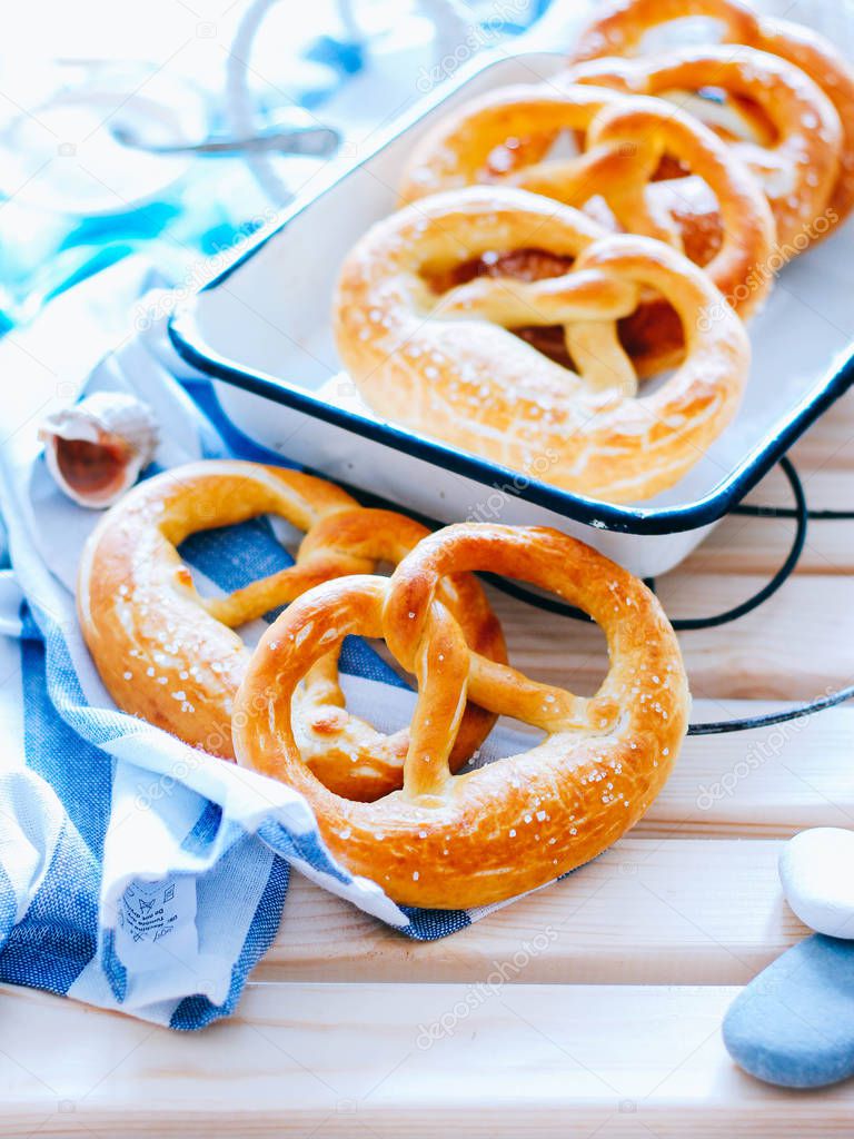 Traditional German pretzels with sea salt on a wooden background in a marine style. Oktoberfest. Homemade baking.