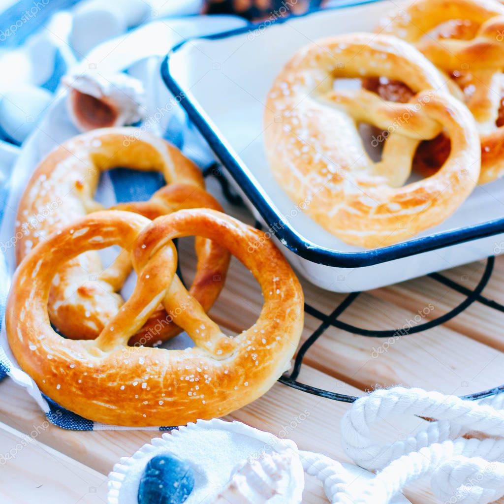 Traditional German pretzels with sea salt on a wooden background in a marine style. Oktoberfest. Homemade baking.