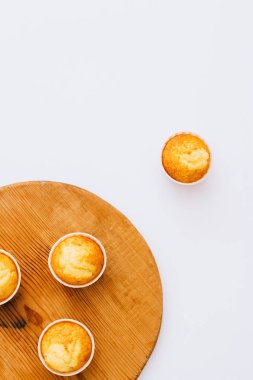 Düz minimalizm ev yapımı turuncu muffins ahşap masa, beyaz arka plan, üstten görünüm, kopya alanı üzerinde yatıyordu.