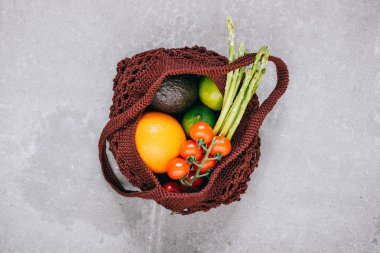 Natürmort kahverengi biyobozunur alışveriş çantası gri arka planda, üstten görünüm, çiğ sebze ile düz yatıyordu