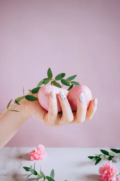 The girl is holding in hand a pink easter egg, pink and marble background, minimalism, flowers