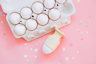 Paskalya kavramı, düz yatıyordu tavuk yumurtası ve pembe bir arka plan üzerinde canlı konfeti. Üstten Görünüm.