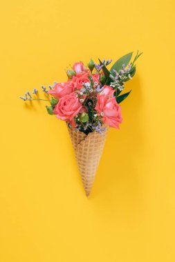 Düz sarı arka plan üzerinde renkli buket ile Dondurma Konisi yatıyordu, kopya alanı