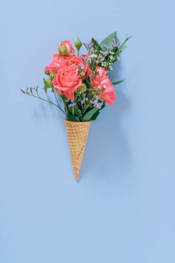 Düz mavi arka plan üzerinde renkli buket ile Dondurma Konileri yatıyordu, kopya alanı