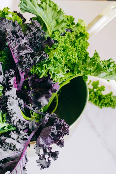 Fresh green and purple kale on a marble background, copy space