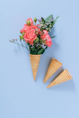 Düz mavi arka plan üzerinde renkli buket ile Dondurma Konileri yatıyordu, kopya alanı