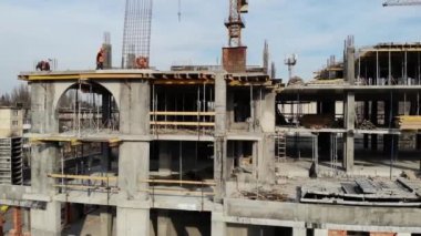 Binanın inşaat sürecinde hava atış. Emek büyük inşaat sitesinde çalışıyor. Arka plan çalışma vinç ve şehir. 4 k Uhd kamera çekim.