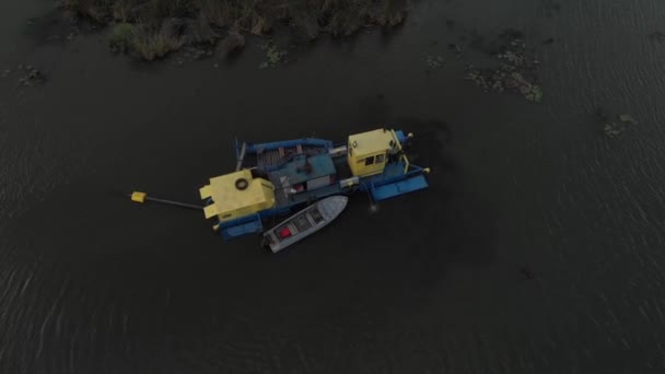 鸟瞰挖掘机和重型设备 疏通和深化河道山河 河岸上的重型挖泥机 挖掘机疏通一条河 — 图库视频影像