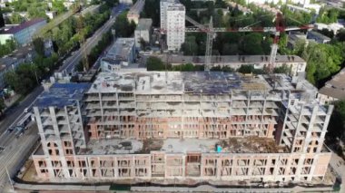 Binanın inşaat sürecinde hava atış. Emek büyük inşaat sitesinde çalışıyor. Arka plan çalışma vinç ve şehir. 4 k Uhd kamera çekim.