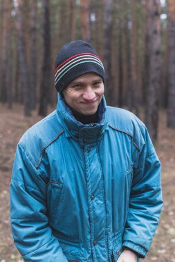 Kırsal bir adam bir çam ormanında sonbahar zamanında poz