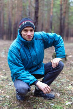 Kırsal bir adam bir çam ormanında sonbahar zamanında poz