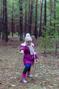 Sevimli küçük kız çam ormanında sonbahar.