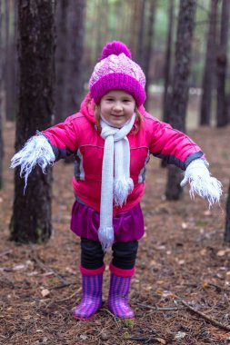 Sevimli küçük kız çam ormanında sonbahar.