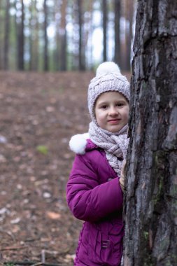 Sevimli küçük kız çam ormanında sonbahar.
