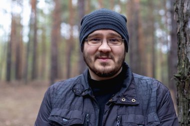 Bir çam ormanı şişko bir genç adam portresi.