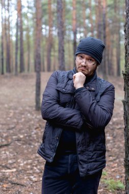 Bir çam ormanı şişko bir genç adam portresi.