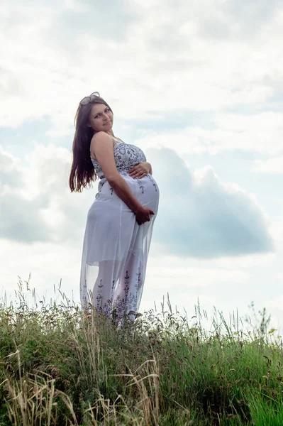 Zwangere Vrouw Een Witte Jurk Een Weiland Tegen Een Hemel — Stockfoto