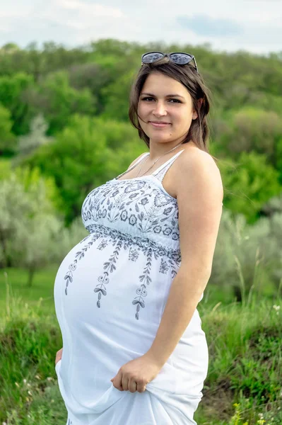Kobieta Ciąży Białej Sukni Odpoczynek Łące Kwitnące Latem — Zdjęcie stockowe