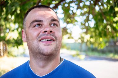 Genç adam bir kırık diş olan mavi bir tişört.