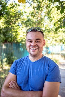 Genç adam bir kırık diş olan mavi bir tişört.