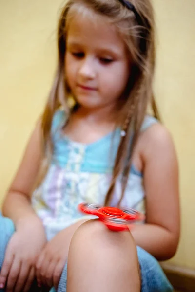 Маленькая Девочка Играет Красной Игрой Прядильщик Снять Стресс Дома — стоковое фото