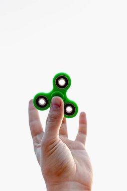 Yeşil topluca spinner tutan bir erkek eli yakın çekim.