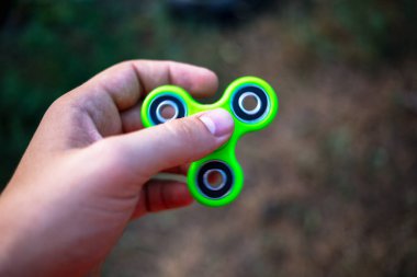 Yeşil topluca spinner tutan bir erkek eli yakın çekim.