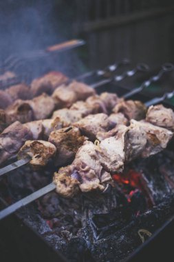 Metal şişleri (ızgara) yemek ızgara kebap. Dumanlı Barbekü, kavrulmuş et pişirilir. Barbekü taze domuz eti et chop dilimleri kadar kapatın. Geleneksel Doğu çanak, şiş kebap. Panjur kömür ve alev, piknik, sokak gıda. Tonda, stil, klasik fotoğraf