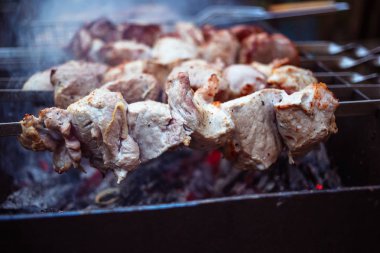 Metal şişleri (ızgara) yemek ızgara kebap. Dumanlı Barbekü, kavrulmuş et pişirilir. Barbekü taze domuz eti et chop dilimleri kadar kapatın. Geleneksel Doğu çanak, şiş kebap. Panjur kömür ve alev, piknik, sokak gıda. Tonda, stil, klasik fotoğraf