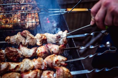 Metal şişleri (ızgara) yemek ızgara kebap. Dumanlı Barbekü, kavrulmuş et pişirilir. Barbekü taze domuz eti et chop dilimleri kadar kapatın. Geleneksel Doğu çanak, şiş kebap. Panjur kömür ve alev, piknik, sokak gıda. Tonda, stil, klasik fotoğraf