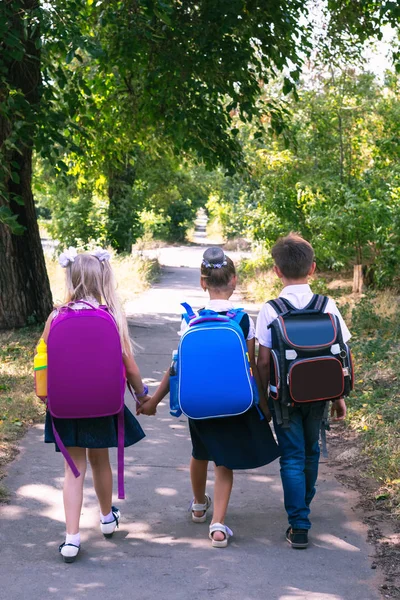 Drie Basisschool Leerlingen Met Rugzakken Wandelen Langs Stoep — Stockfoto