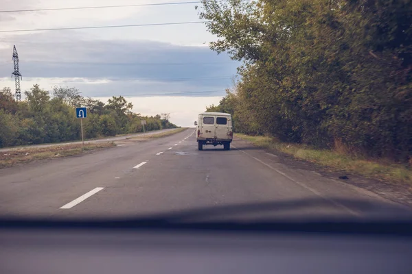 The old rarity van is on the road. View from the car