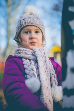 Sonbaharda bir oyun alanı üzerinde sevimli küçük bir kız