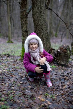 sevimli küçük kız sonbahar ormanda poz.