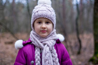 sevimli küçük kız sonbahar ormanda poz.