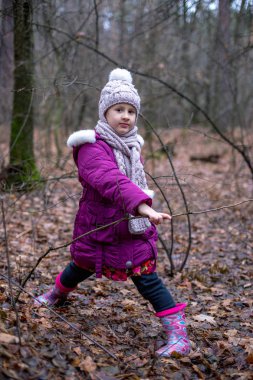 sevimli küçük kız sonbahar ormanda poz.