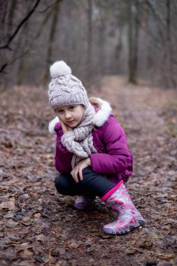Küçük şirin kız sonbahar orman yolundaki oturuyor