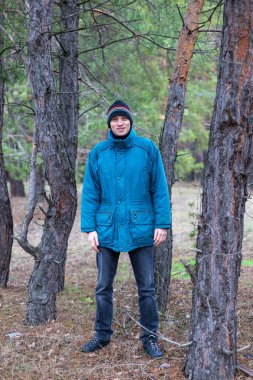 Kırsal bir adam bir çam ormanında sonbahar zamanında poz