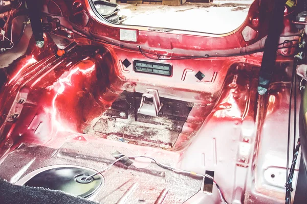 Disassembled car interior. Preparation for noise and vibration isolation. Work in a car repair shop.