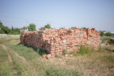 Sokakta tuğla yığını. Yaz, gökyüzü ve çim.