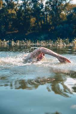 Genç adam nehirde yüzüyor..