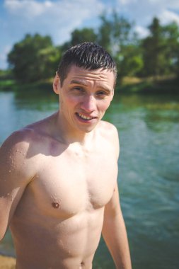 Yazın nehir kenarında genç bir adamın portresi..