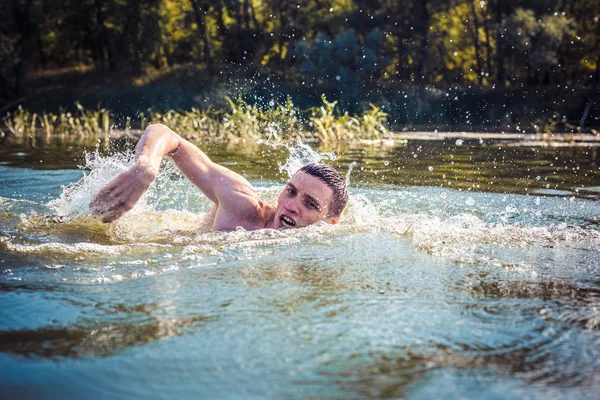 The young man swimming in the river.