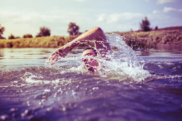 De jongeman die in de rivier zwemt — Stockfoto