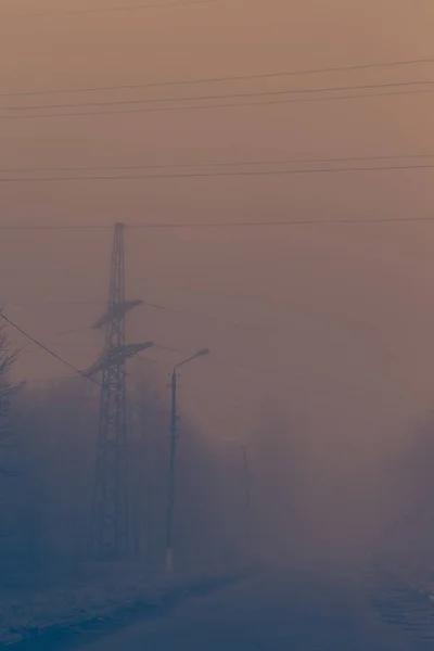 Polo de alto voltaje en la niebla — Foto de Stock