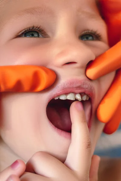 El doctor está tratando de ver la boca de una niña con una o —  Fotos de Stock