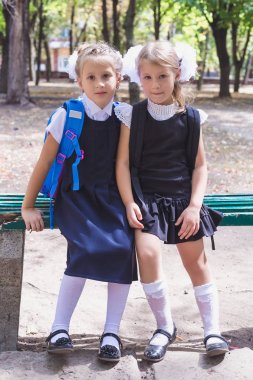 Parkta sırt çantası olan iki kız öğrenci.