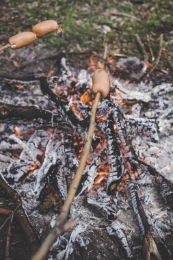 Ormanda bir yangında kızarmış sosis pişirme